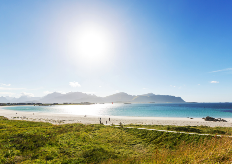 plage ensoleillée avec des montagnes et des gens dans les Lofoten, en Norvège
